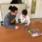 Medewerker is met een cliënt een puzzel aan het maken